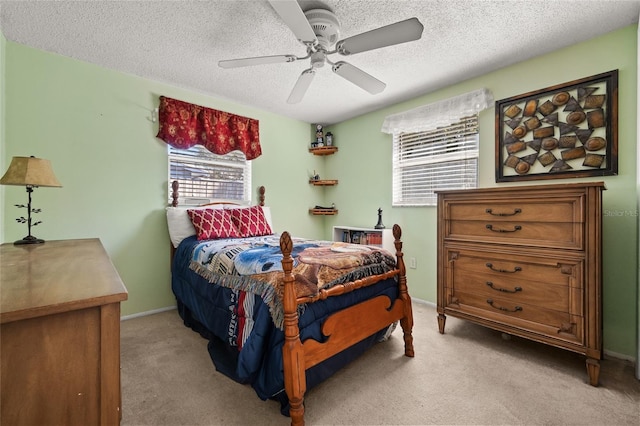 carpeted bedroom with ceiling fan and a textured ceiling