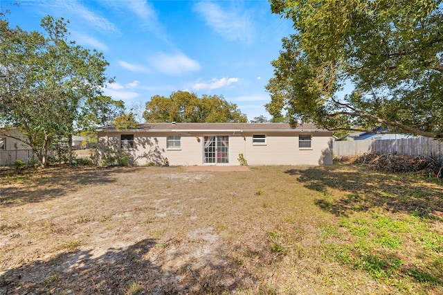 rear view of property with a lawn