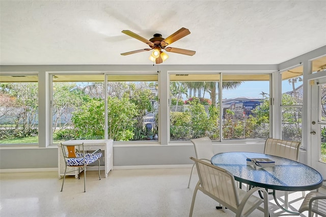 sunroom featuring ceiling fan and plenty of natural light