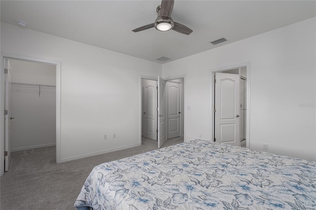 carpeted bedroom featuring ceiling fan, a spacious closet, and a closet