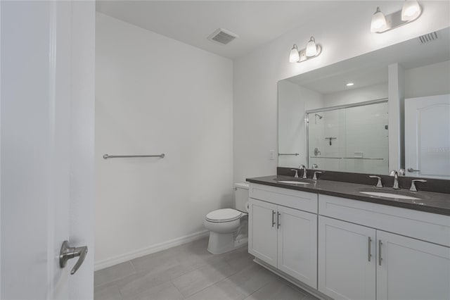 bathroom with toilet, a shower with door, tile patterned floors, and vanity