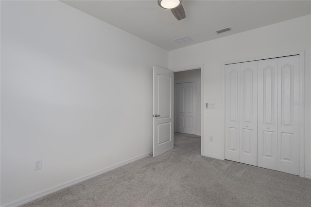 unfurnished bedroom with ceiling fan, a closet, and light carpet