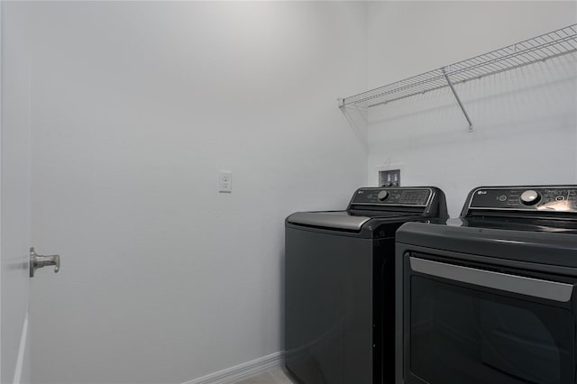 clothes washing area with tile patterned floors and washing machine and clothes dryer