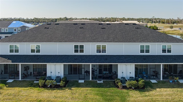 back of property with a yard and a sunroom