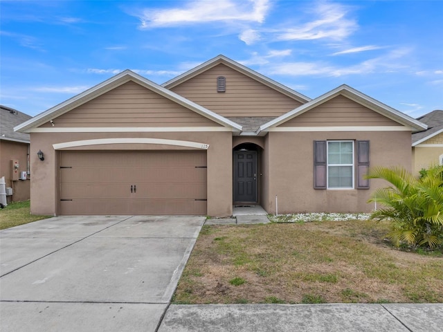 ranch-style home with a garage and a front lawn