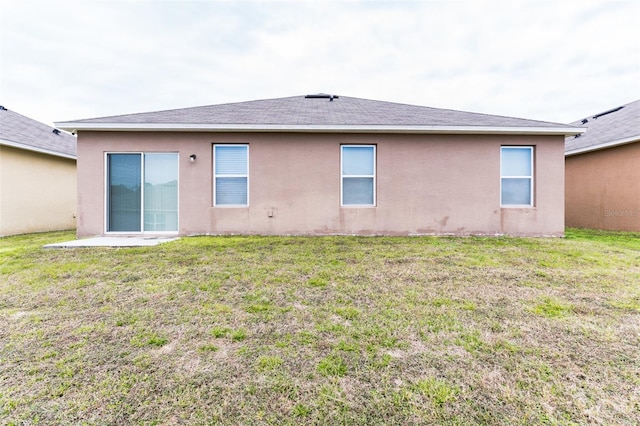 rear view of house featuring a yard