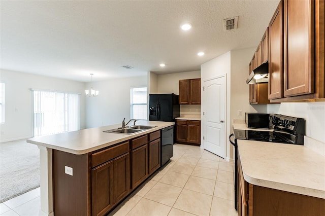 kitchen with hanging light fixtures, an island with sink, black appliances, light carpet, and sink