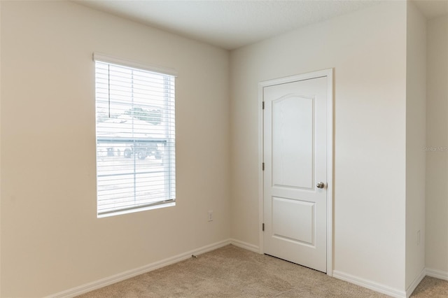 unfurnished room with light carpet