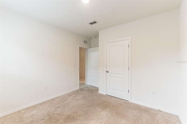 unfurnished bedroom featuring light carpet