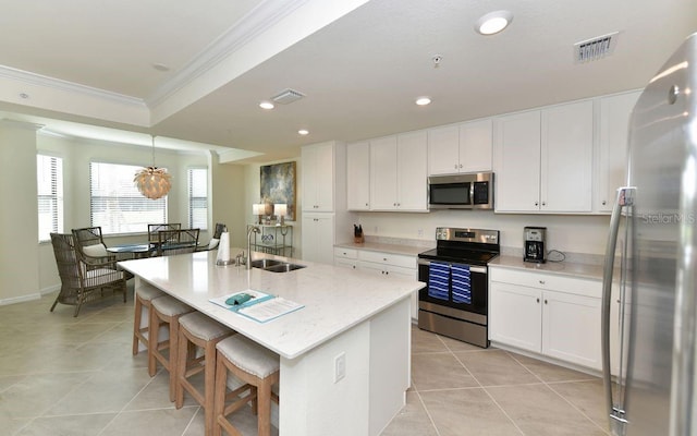 kitchen featuring an island with sink, appliances with stainless steel finishes, white cabinets, and sink