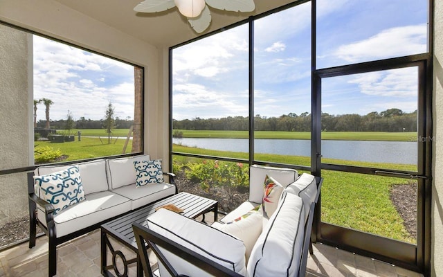 sunroom featuring ceiling fan and a water view