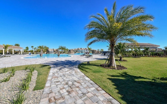 surrounding community featuring a gazebo, a patio area, a lawn, and a swimming pool