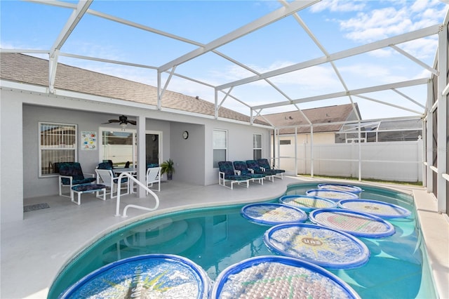 view of swimming pool featuring ceiling fan, glass enclosure, a patio area, and a jacuzzi