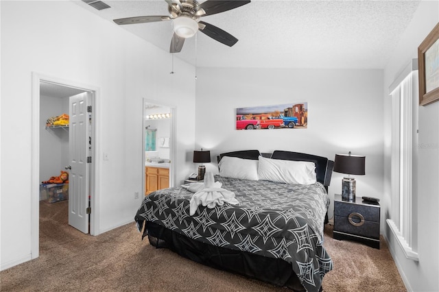 bedroom featuring a textured ceiling, lofted ceiling, connected bathroom, carpet flooring, and ceiling fan