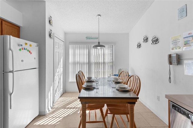 tiled dining room with a textured ceiling