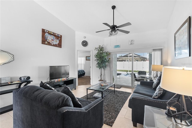 living room featuring ceiling fan, light tile patterned floors, and vaulted ceiling