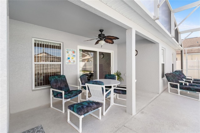 view of patio featuring ceiling fan and glass enclosure