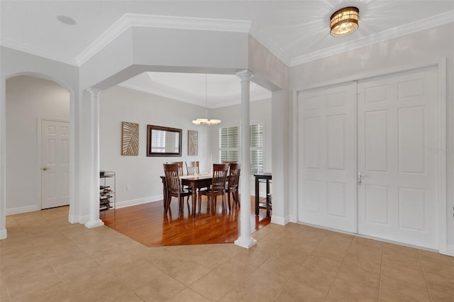 tiled dining space with an inviting chandelier and ornamental molding