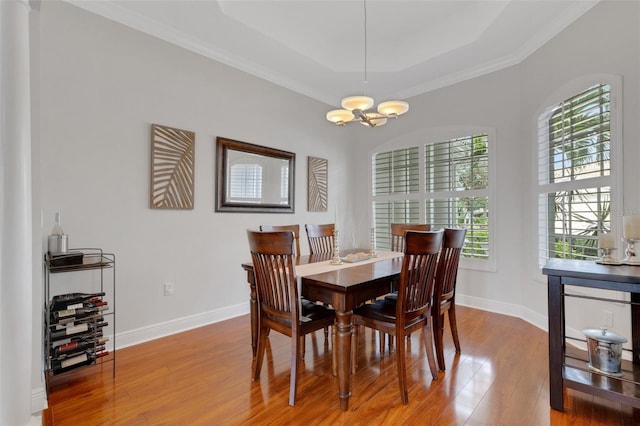 dining room with plenty of natural light, a tray ceiling, a chandelier, and hardwood / wood-style floors