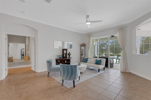 tiled living room with ceiling fan and ornamental molding