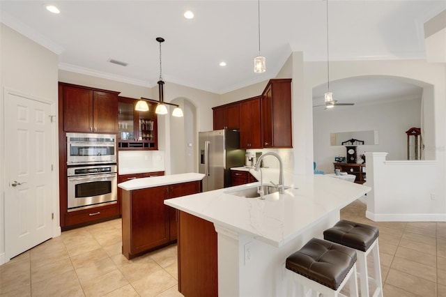 kitchen with decorative light fixtures, sink, kitchen peninsula, and stainless steel appliances