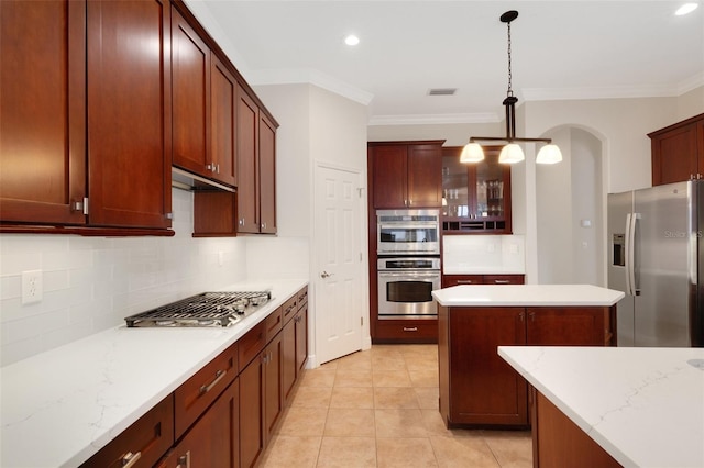 kitchen with backsplash, crown molding, hanging light fixtures, appliances with stainless steel finishes, and light tile patterned floors