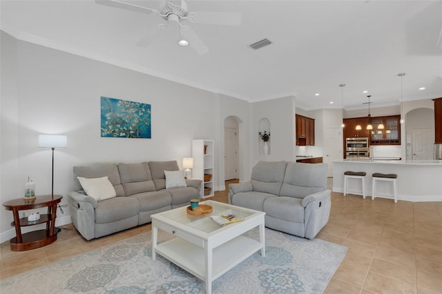 living room with ceiling fan, light tile patterned floors, and crown molding