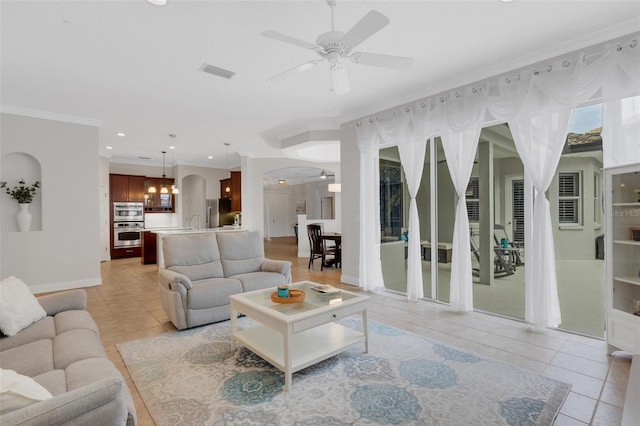 tiled living room featuring ceiling fan, sink, and crown molding