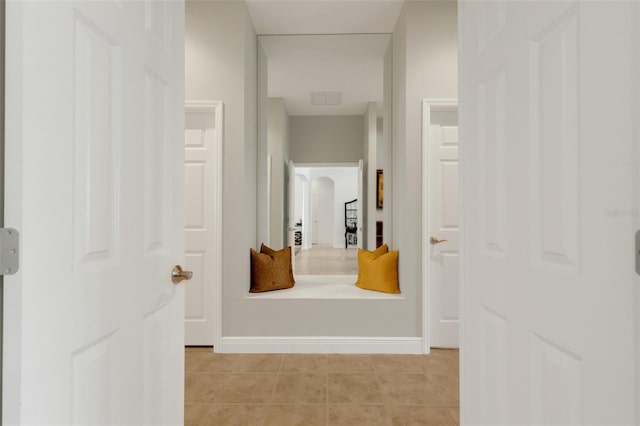 hall featuring light tile patterned floors