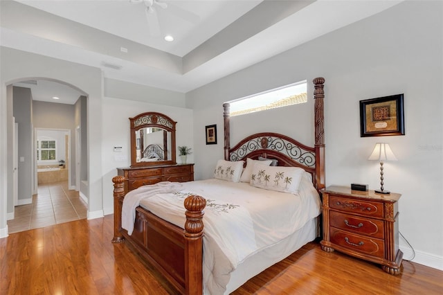 bedroom featuring ceiling fan, ensuite bathroom, and light hardwood / wood-style floors