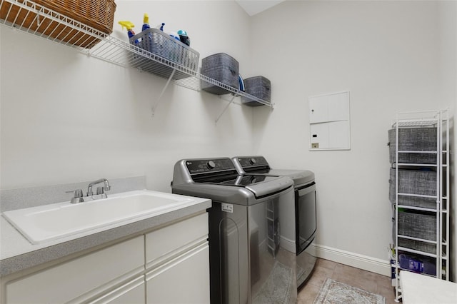 laundry room with cabinets, washing machine and clothes dryer, and sink