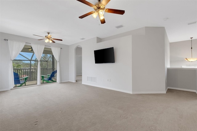 unfurnished living room with ceiling fan and carpet