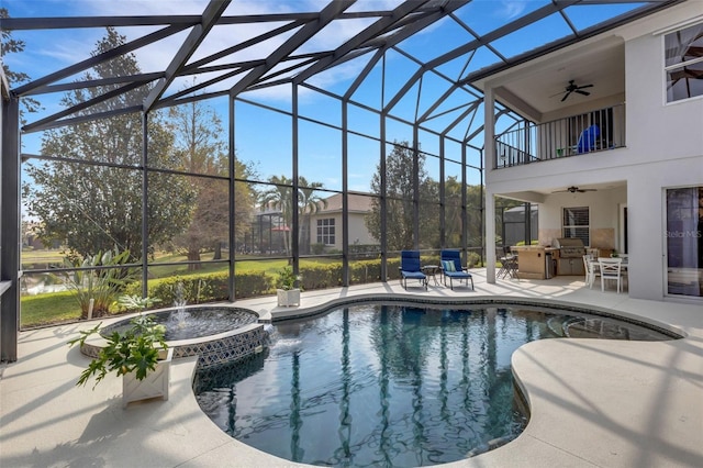 view of swimming pool with ceiling fan, an outdoor kitchen, a patio area, and glass enclosure