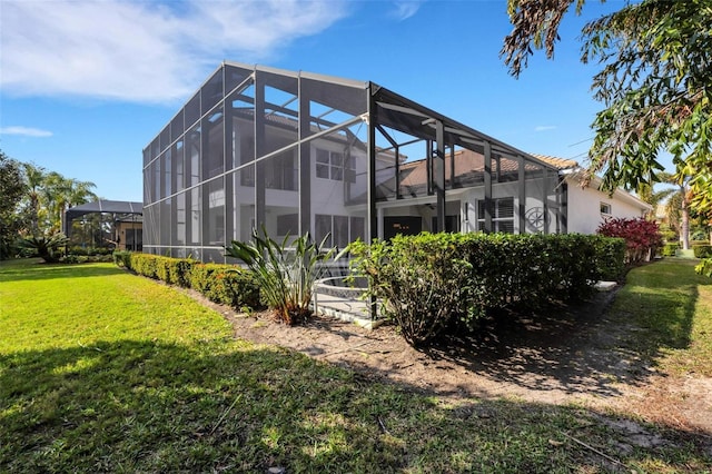 back of property featuring glass enclosure and a yard