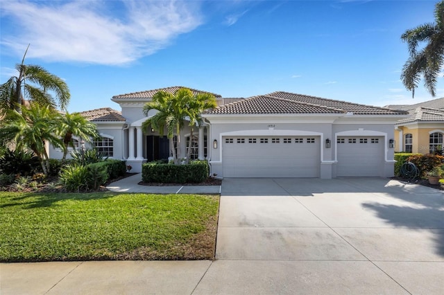 mediterranean / spanish house featuring a front yard and a garage