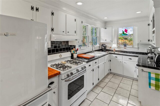 kitchen featuring sink, white cabinets, white appliances, ornamental molding, and backsplash