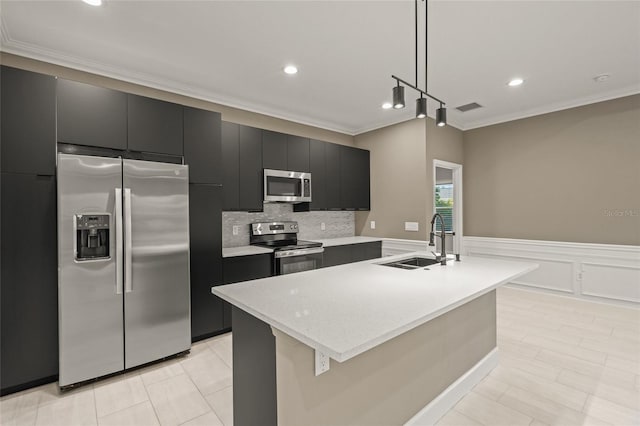 kitchen with appliances with stainless steel finishes, decorative light fixtures, sink, and a center island with sink