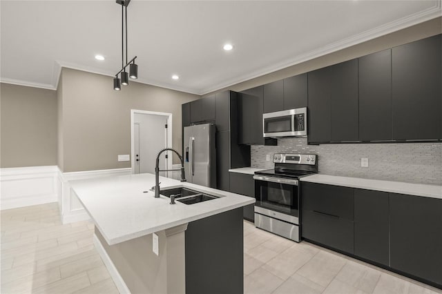 kitchen featuring stainless steel appliances, sink, ornamental molding, a center island with sink, and pendant lighting