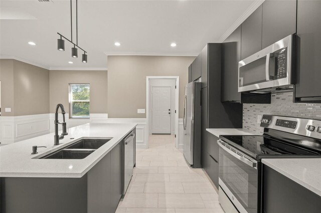 kitchen featuring stainless steel appliances, sink, a center island with sink, pendant lighting, and crown molding