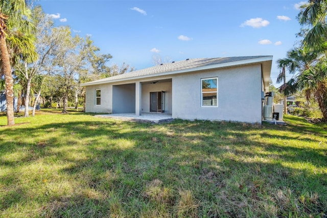 rear view of house with a patio and a yard