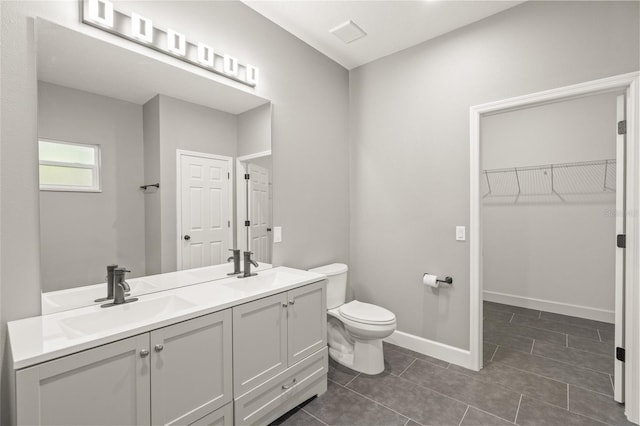 bathroom with toilet, tile patterned floors, and vanity