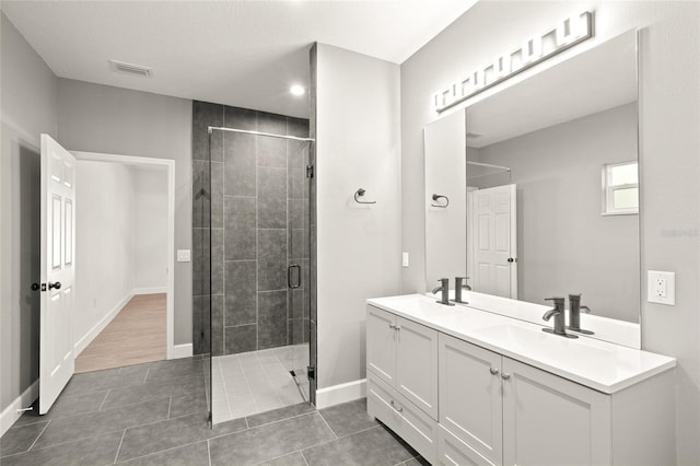 bathroom featuring walk in shower, vanity, and tile patterned floors