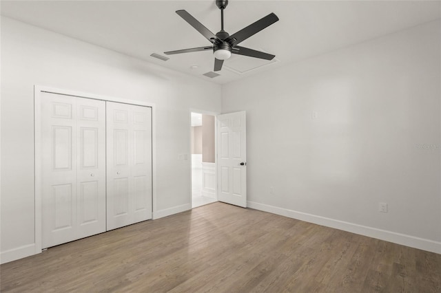 unfurnished bedroom with light wood-type flooring, ceiling fan, and a closet