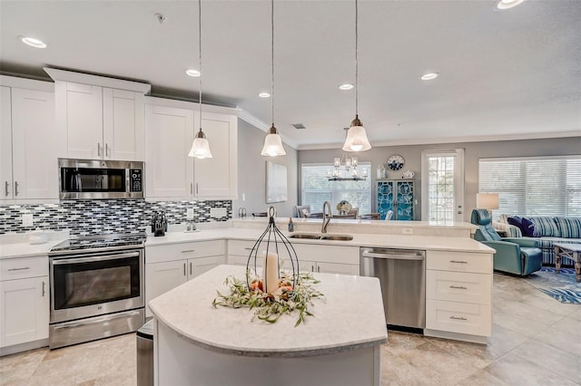 kitchen featuring light countertops, appliances with stainless steel finishes, and hanging light fixtures