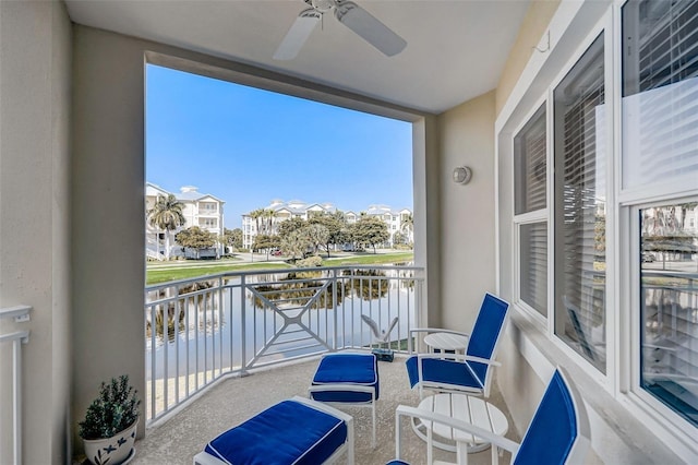 balcony featuring a water view and ceiling fan