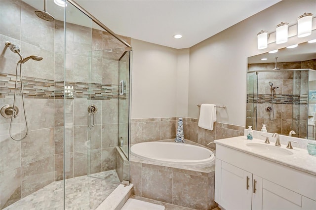 bathroom featuring a garden tub, vanity, and a stall shower