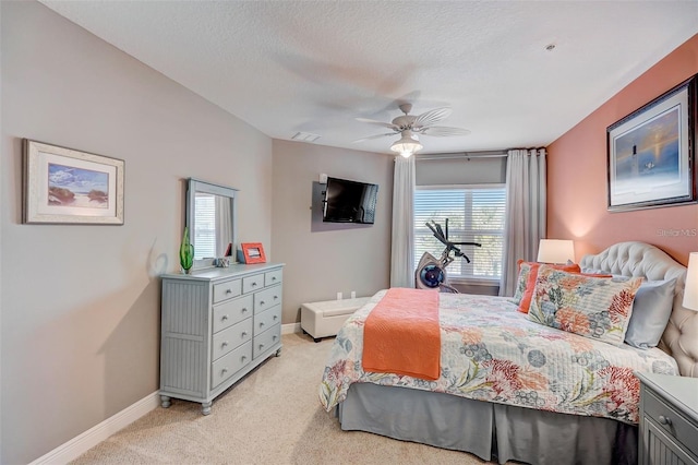 bedroom with light carpet, a textured ceiling, visible vents, and baseboards