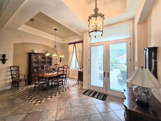 interior space featuring french doors, an inviting chandelier, ornamental molding, and a raised ceiling