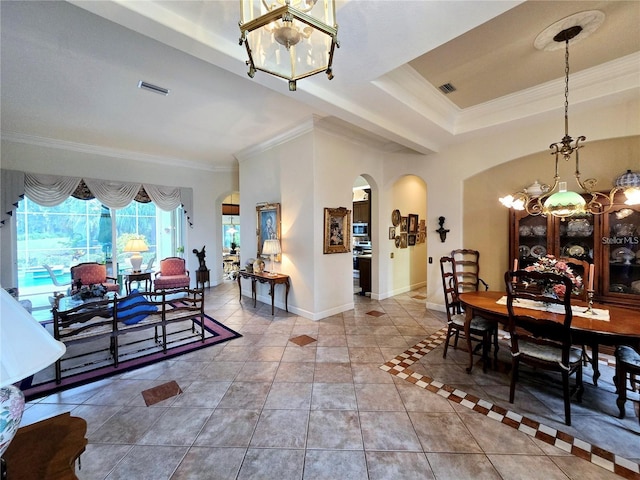 tiled dining area with a tray ceiling, an inviting chandelier, and ornamental molding