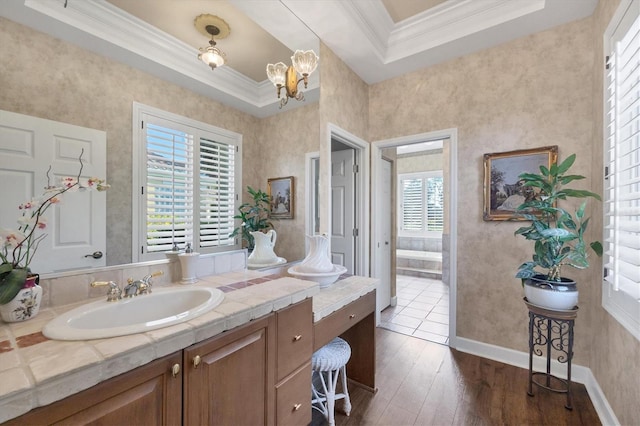 bathroom featuring ornamental molding, plenty of natural light, wood-type flooring, and vanity